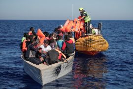 Crew members of NGO rescue ship 'Ocean Viking' give lifejackets to refugees and migrants on an overcrowded boat in the Mediterranean Sea, October 25, 2022.