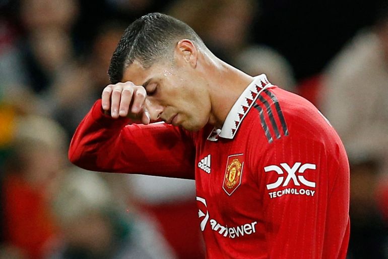 Ronaldo in red uniform wiping sweat from his brow