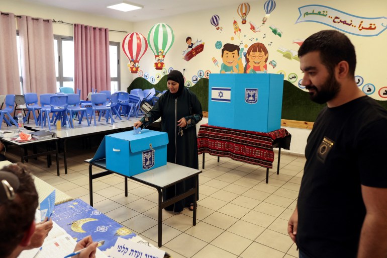An Israeli Palestinian woman votes in a school classroom that has been turned into a polling station.