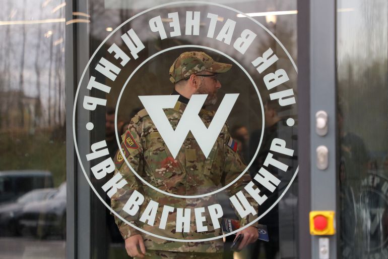 Glass door with the round Wagner symbol and man in military camouflage behind