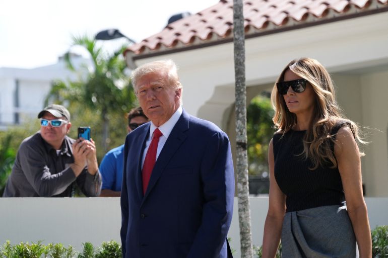 Donald Trump and his wife Melania Trump walk outside a Florida polling station
