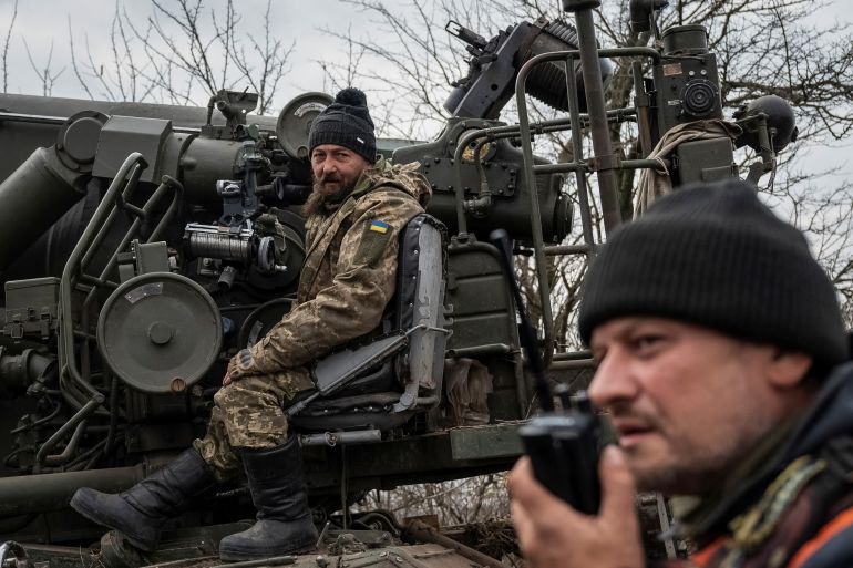 Ukrainian soldiers, the one closest to the camera speaking on a walkie talkie and the one behind preparing to fire a 2S7 Pion self-propelled gun at Russian positions in Kherson region