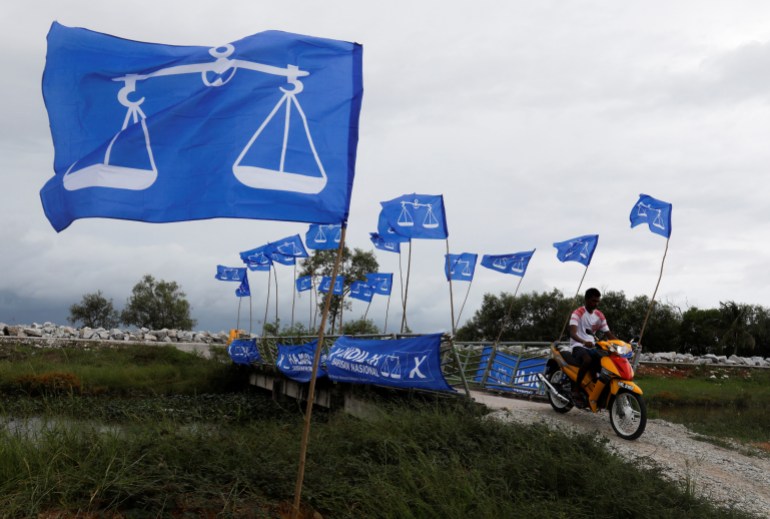 The blue flags with a white balancing scale that are the symbol of BN along a rural road in Malaysia