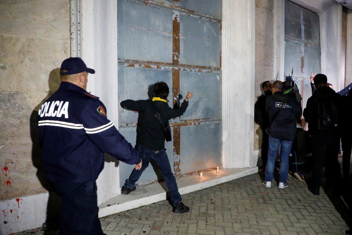 A man hits the door of Prime Minister Edi Rama's office during anti-government protest