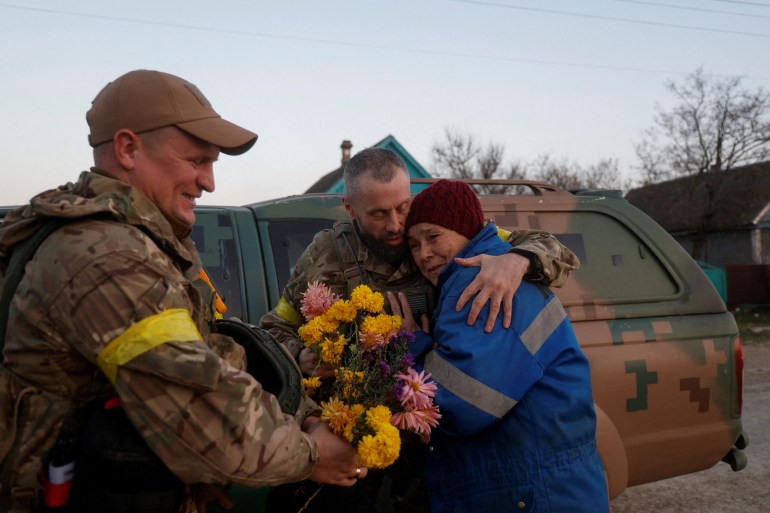 Resident Valentyna Buhaiova embraces Ukrainian marines in the recently retaken village of Kyselivka, outside of Kherson, Ukraine.