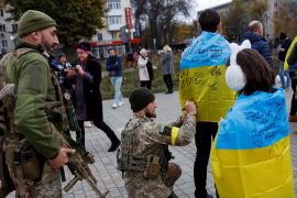 A Ukrainian serviceman gives an autograph to a local resident in central Kherson, Ukraine November 16, 2022. REUTERS/Murad Sezer
