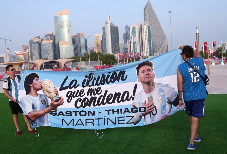 Argentina fans display a banner showing Diego Maradona and Lionel Messi.