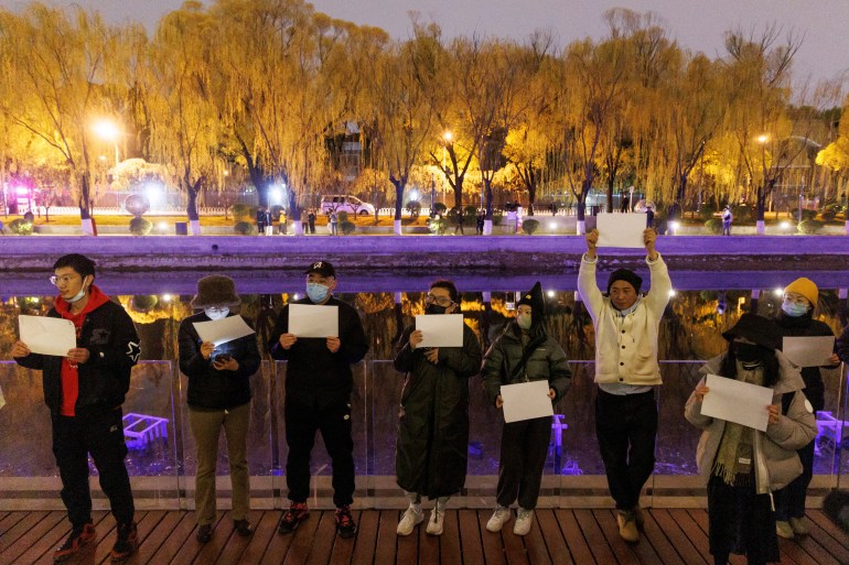 Protesters in Beijing holds up blank sheets of white paper as a protest against censorship