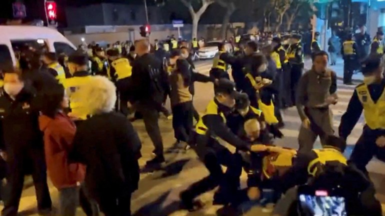 Police detain people at a protest in Shanghai