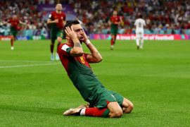 Bruno Fernandes celebrates a goal on his knees while grabbing his head.