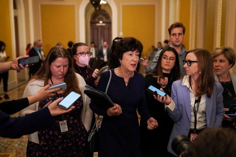 US Senator Susan Collins surrounded by reporters in halls of Congress