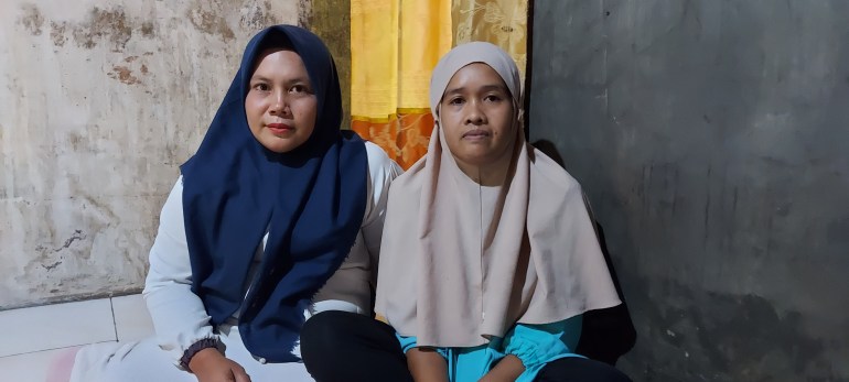 Mohammad Fajar's Mum, Siti, in a pale pink headscarf and turquoise shirt with her cousin Sri Wulandari in a navy blue headscarf and white dress sitting inside Siti's house