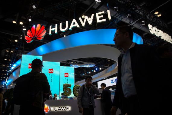 People file past a stall advertising Huawei at the PT Expo in Beijing