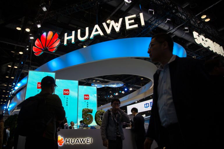 People file past a stall advertising Huawei at the PT Expo in Beijing