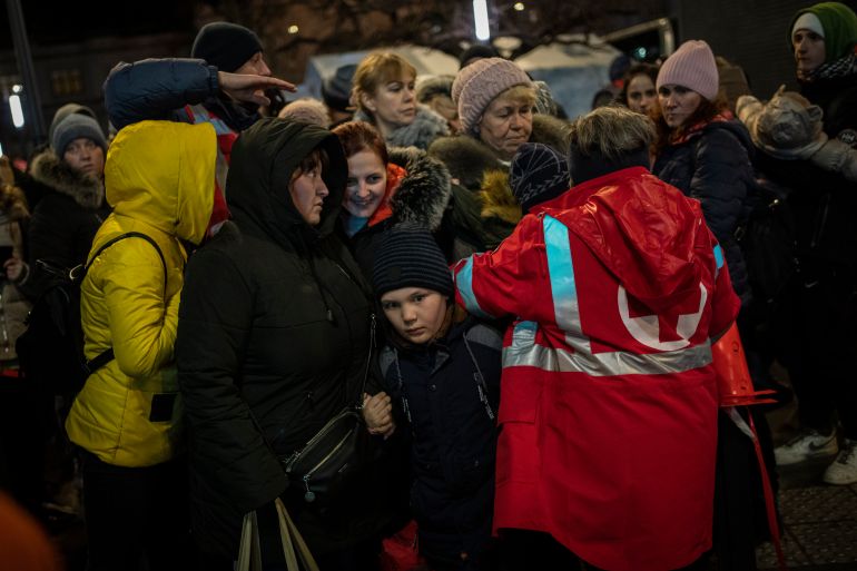 Displaced Ukrainians queue to board a bus to Poland outside Lviv train station in western Ukraine on March 5, 2022