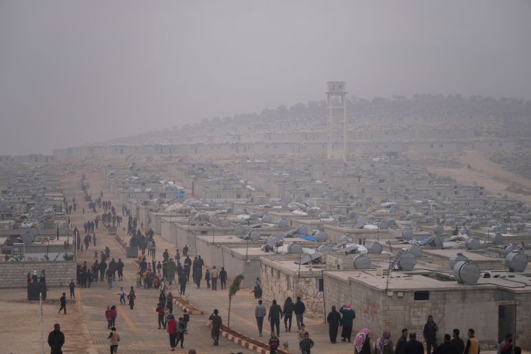 Syrians walk along in a refugee camp for displaced people run by the Turkish Red Crescent in Sarmada district, north of Idlib city, Syria, Nov. 26, 2021