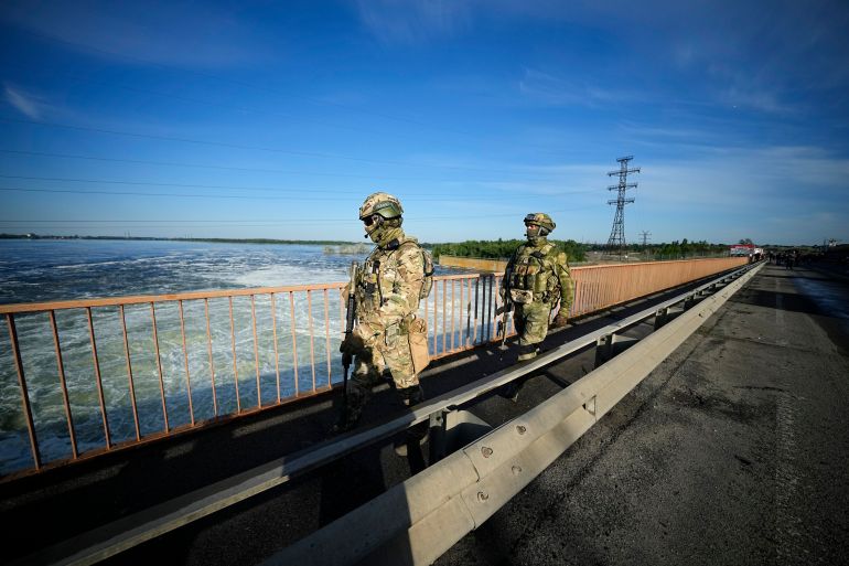 Russian troops patrol an area at the Kakhovka Hydroelectric Station on the Dnieper River in Ukraine's Kherson region