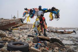 "Plastic Man", poses for a photo at the Yarakh Beach littered by trash and plastics in Dakar, Senegal.
