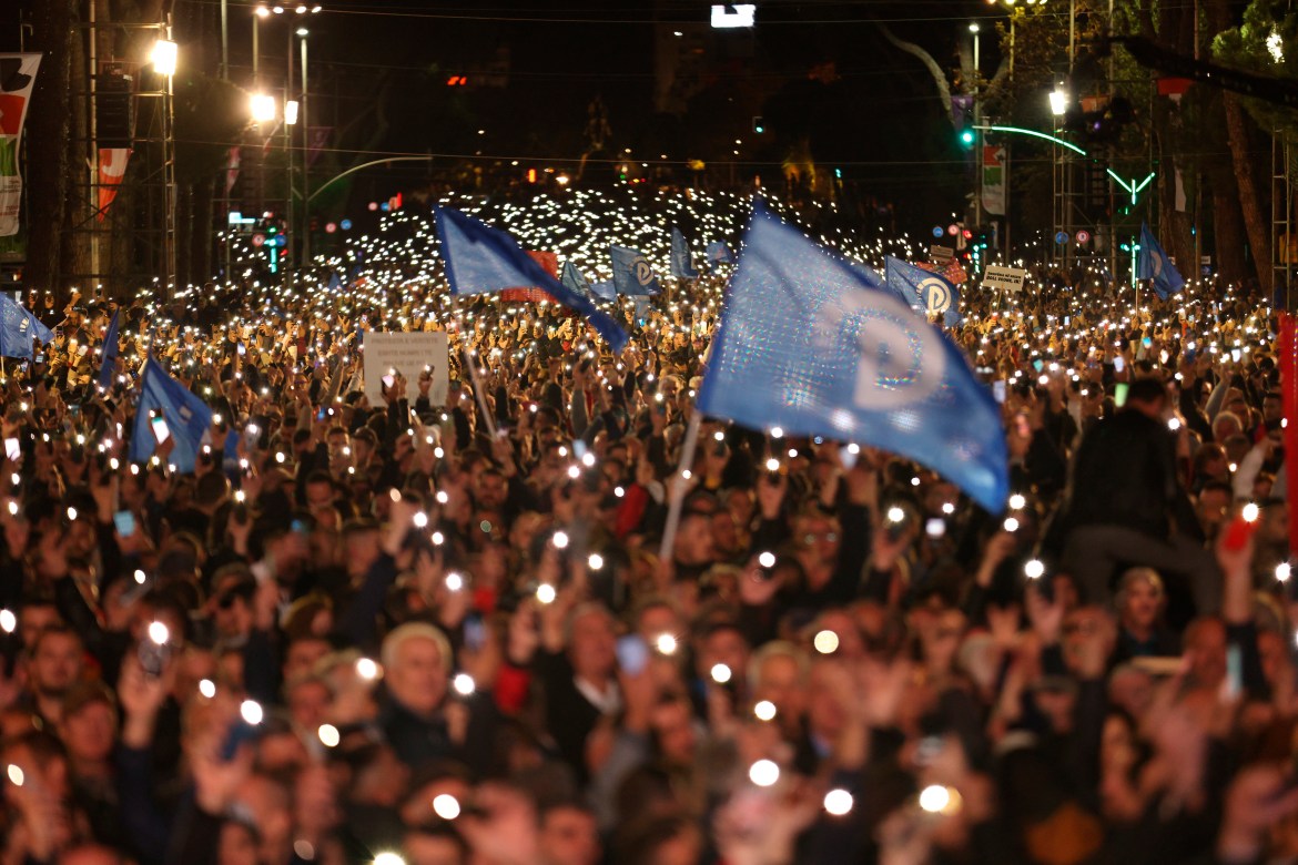 Protesters raise their mobile phones flashlights during an anti-government rally in Tirana