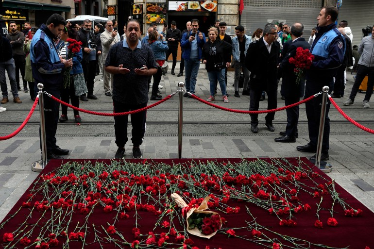 A man mourns in front of a memorial placed on the spot of Sunday's explosion on Istanbul's popular pedestrian Istiklal Avenue in Istanbul, Monday, Nov. 14, 2022. Police have arrested a suspect who is believed to have planted the bomb that exploded on a bustling pedestrian avenue in Istanbul, Turkey’s interior minister said Monday, adding that initial findings indicate that Kurdish militants were responsible for the deadly attack.(AP Photo/Khalil Hamra)