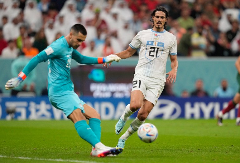 Portugal's goalkeeper Diogo Costa kicks the ball ahead of Uruguay's Edinson Cavani 