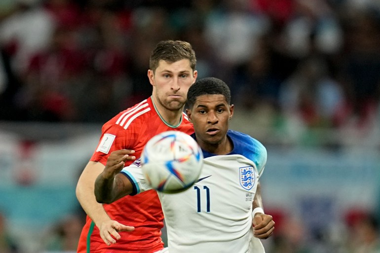 Wales' Ben Davies, left, and England's Marcus Rashford battle for the ball 
