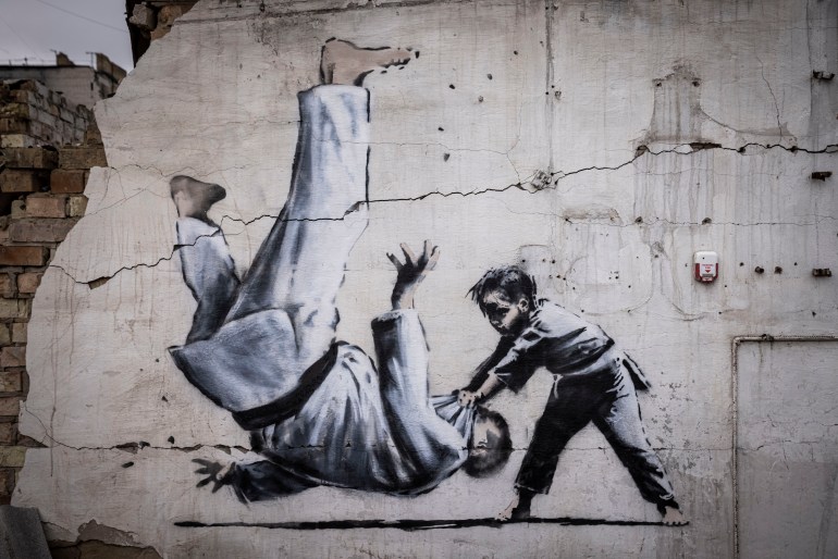 Graffiti of a child throwing a man on the floor in judo clothing 