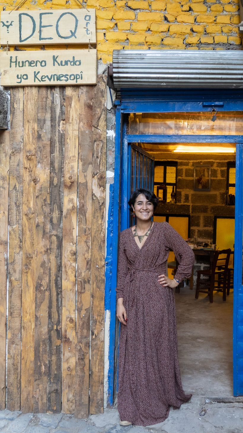 A photo of Fatê Temel standing outside her Deq studio in Diyarbakır’s historic Sur district, which she opened in November last year.