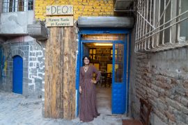 A photo of Fatê Temel standing outside her Deq studio in Diyarbakır’s historic Sur district, which she opened in November last year.