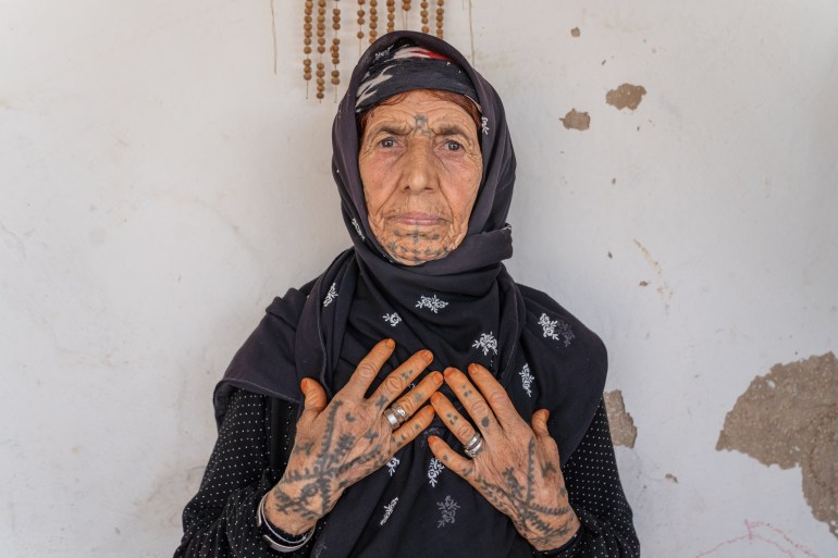A photo of Saliha Özşavlı showing the tattoos on her hands and chin. On Saliha Özşavlı’s chin, right below her lips, is a symbolic motif representing abundance, fertility, enlightenment, immortality, birth, healing, and happiness, according to Yavuklu, the Kurdish anthropologist. The three dots on her fingers are requests to God to keep her husband loyal when she had feared he may get another wife.