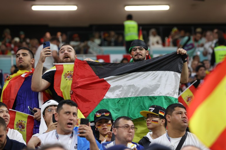 Fans hold a Palestiniian flag before the match |Spain v Germany, Group E, FIFA World Cup 2022, November 27, Al Bayt Stadium [Showkat Shafi/Al Jazeera]