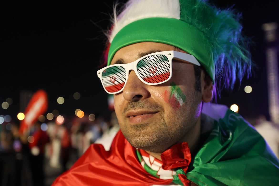 Iran fan with glass lenses painted with Iran's flag, wearing a cape of red, white and green, and a green and white hat