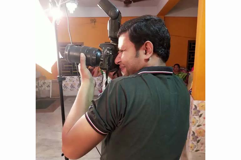 A photo of Arijit working as a wedding photographer to manage his family expenses.