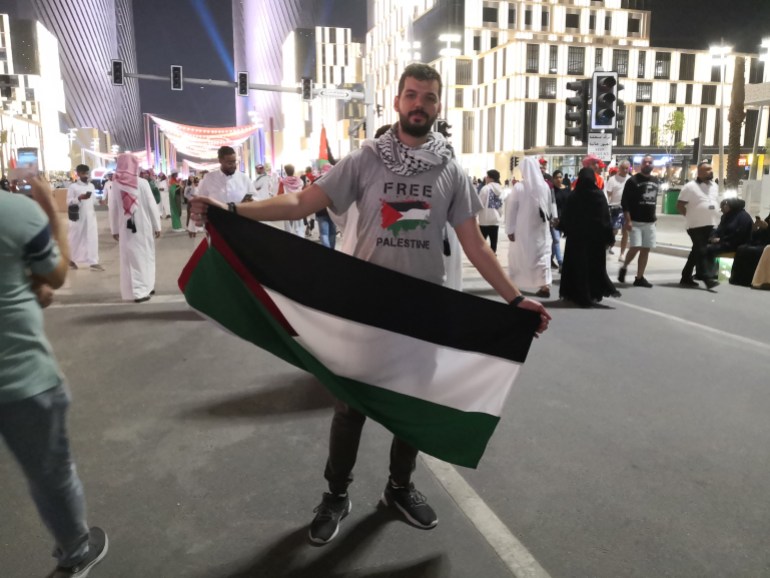 A man named Bader holds up a Palestinian flag