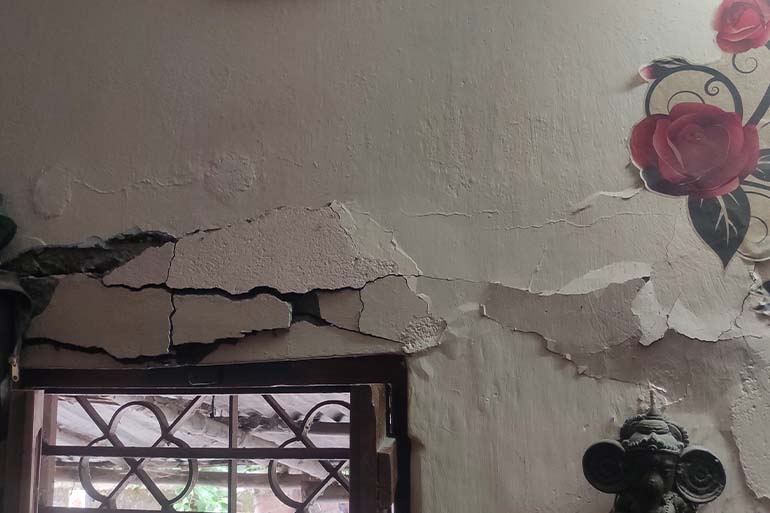 A photo of cracks in the wall of his room which is unable to repair due to financial crisis.