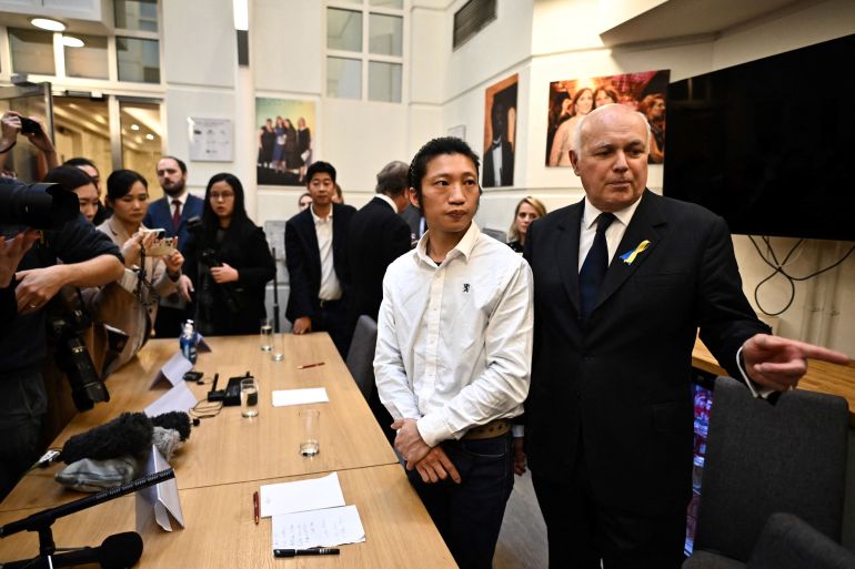 Protester Bob Chan and British MPs Iain Duncan Smith hold news conference in London.