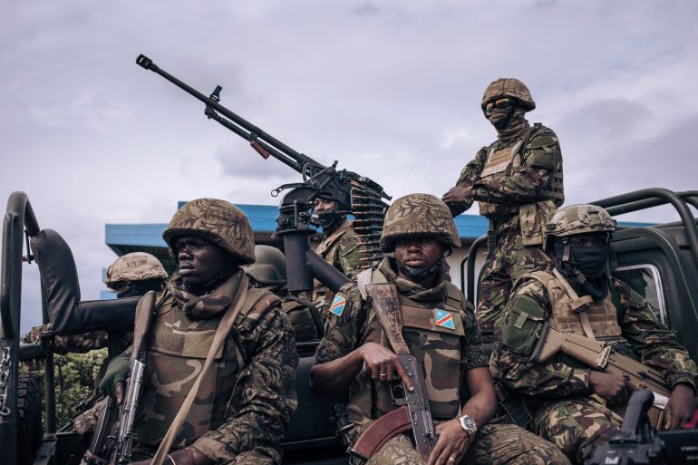 An escort of Kenyan and Congolese military personnel stands guard at the airport in Goma, eastern Democratic Republic of Congo