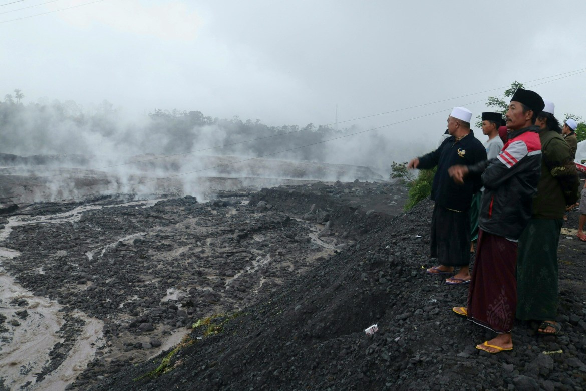 Villagers watch hot smoke from the ground