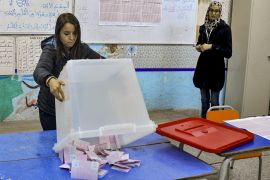 An ISIE agent begins counting ballots at a polling station in Tunis on December 17, 2022, during the parliamentary election [Yacine Mahjoub/AFP]