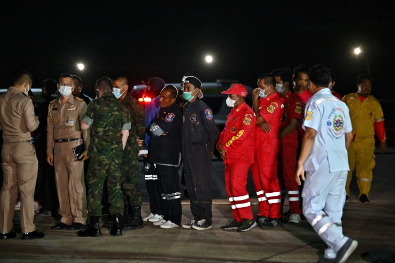 Army personnel and rescue crew gather at a makeshift rescue operation site during the search for survivors of the capsizing of the Thai naval vessel HTMS Sukhothai about 37 kilometres (22 miles) off the southeastern coast on Sunday night, at Bang Saphan Pier in Prachuap Khiri Khan district, on December 19, 2022. - Thai military frigates and helicopters were on December 19 searching for 31 sailors after a naval vessel sank, with dozens of others having been hauled from choppy waters. (Photo by Lillian SUWANRUMPHA / AFP)