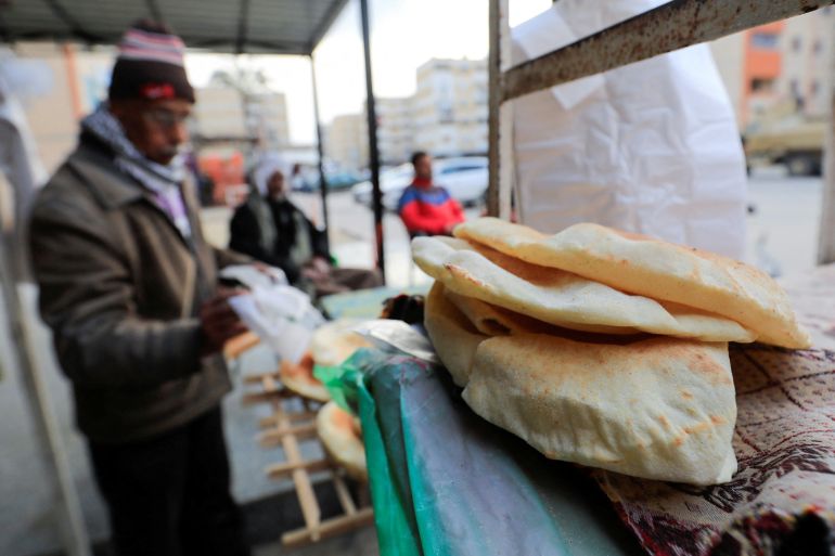 An Egyptian baker sells bread outside a bakery at newly homes area of Al-Arish city