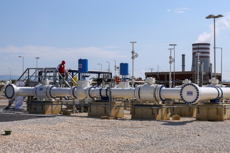 A member of the staff stands over a part of the Interconnector Greece-Bulgaria (IGB) gas pipeline that will carry gas from Komotini to Stara Zagora in Bulgaria, in Komotini, Greece