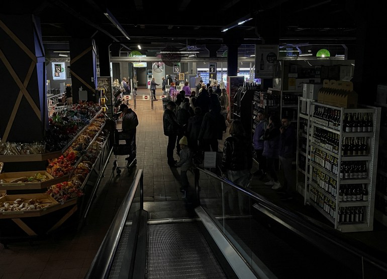 People shop in a supermarket without electricity in Kyiv