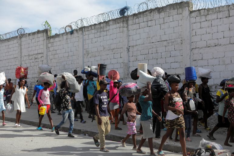 People displaced by gang war violence in Cite Soleil walk on the streets of Delmas neighborhood after leaving Hugo Chaves square in Port-au-Prince, Haiti November 19, 2022. REUTERS/Ralph Tedy Erol