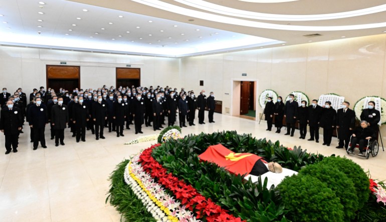 Chinese President Xi Jinping and others pay their final respects to Jiang Zemin, whose body is draped with a Chinese flag, at a military hospital in Beijing 