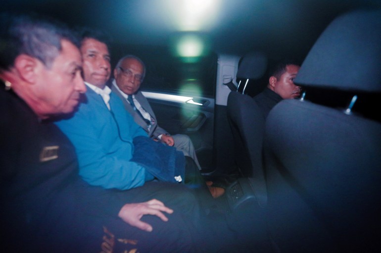 Pedro Castillo sitting in the back of car next to former prime minister Anibal Torres after leaving the police station in Lima