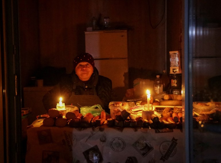 FILE PHOTO: A vendor waits for customers in a small store that is lit with candles during a power outage after critical civil infrastructure was hit by Russian missile attacks, as Russia's invasion of Ukraine continues, in Odesa, Ukraine December 5, 2022. REUTERS/Serhii Smolientsev/File Photo