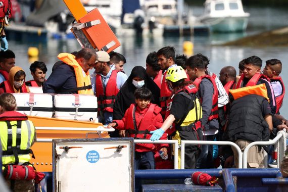 Refugees and migrants arrive at the UK's Dover Harbour on board a Border Force vessel.