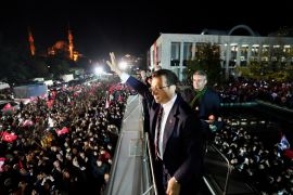 Istanbul Mayor Ekrem Imamoglu greets his supporters as they gather in front of his office