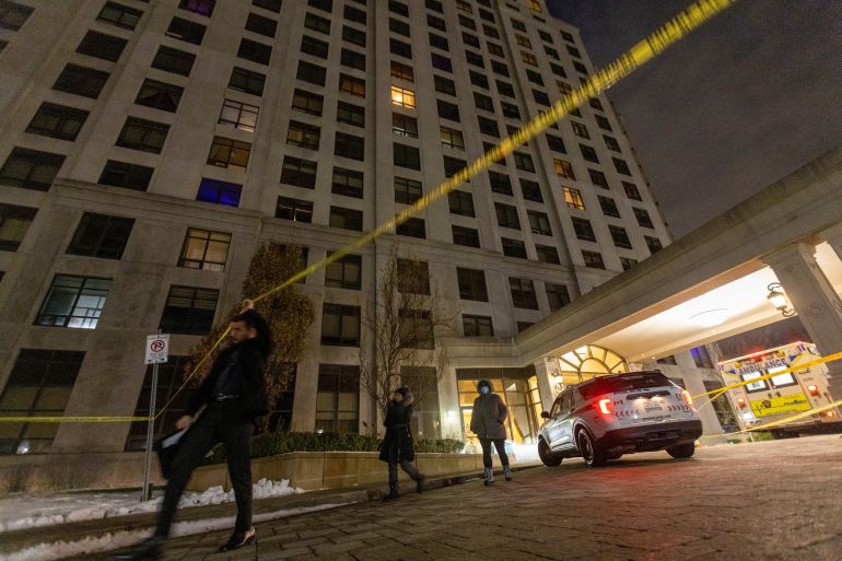 A person walks under the police line after a fatal mass shooting at a condominium building in the Toronto suburb of Vaughan, Ontario, Canada December 19, 2022. REUTERS/Carlos Osorio